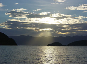 雲間から差し込む太陽の光に照らされる琵琶湖の写真
