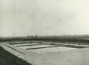 広い土地に長方形の池が並んでいる白黒写真