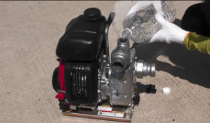 エンジンポンプの横にあるシルバー色の呼び水注水口に水を溜めている写真