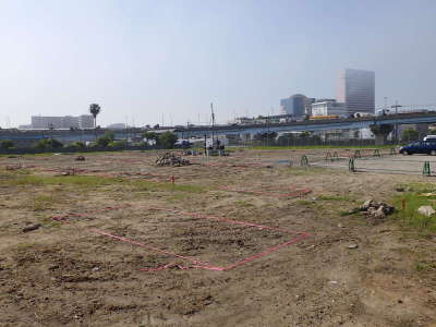 所々草が生えた更地に、赤いビニールテープで印をしている川下水ポンプ場建設地の写真