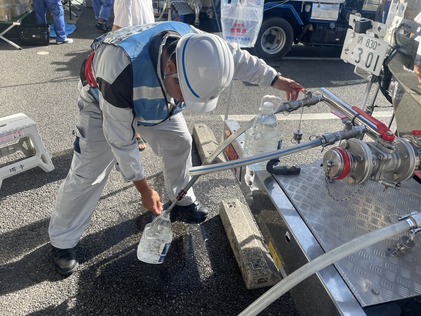 給水タンク車から給水袋へ水を入れている写真