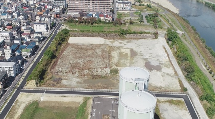 手前にタンクが2基あり奥が更地になっている浅香山浄水場跡地を上空から写した写真
